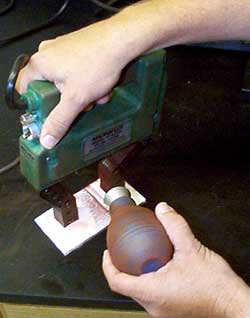 Inspectors dust dry particles on a part as it is magnetized.