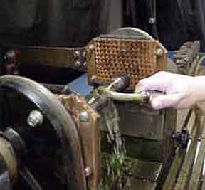 An inspector washes a part with wet suspension as it is magnetized.