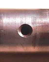 A crack eminating from a hole may be so thin that it is difficult to detect with the unaided eye.