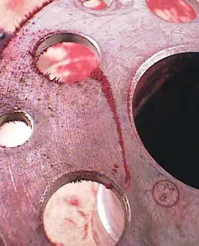 Stress concentrations at fastener hols can cause cracks that connect from one hole to another. Dry magnetic particle can detect these cracks.